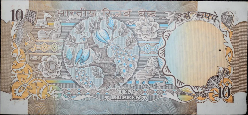 10 Rupees of Republic India (AD 1970-1990) with Two blue peacocks or Indian peafowl (Pavo cristatus) sitting on branches of an old mango tree surrounded by antelopes, horses, flowers, and a bird - R.N. Malhotra