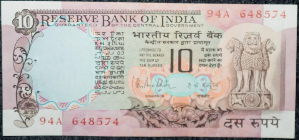 10 Rupees of Republic India (AD 1970-1990) with Two blue peacocks or Indian peafowl (Pavo cristatus) sitting on branches of an old mango tree surrounded by antelopes, horses, flowers, and a bird - R.N
