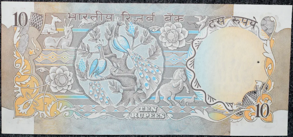 10 Rupees of Republic India (AD 1970-1990) with Two blue peacocks or Indian peafowl (Pavo cristatus) sitting on branches of an old mango tree surrounded by antelopes, horses, flowers, and a bird - R.N. Malhotra