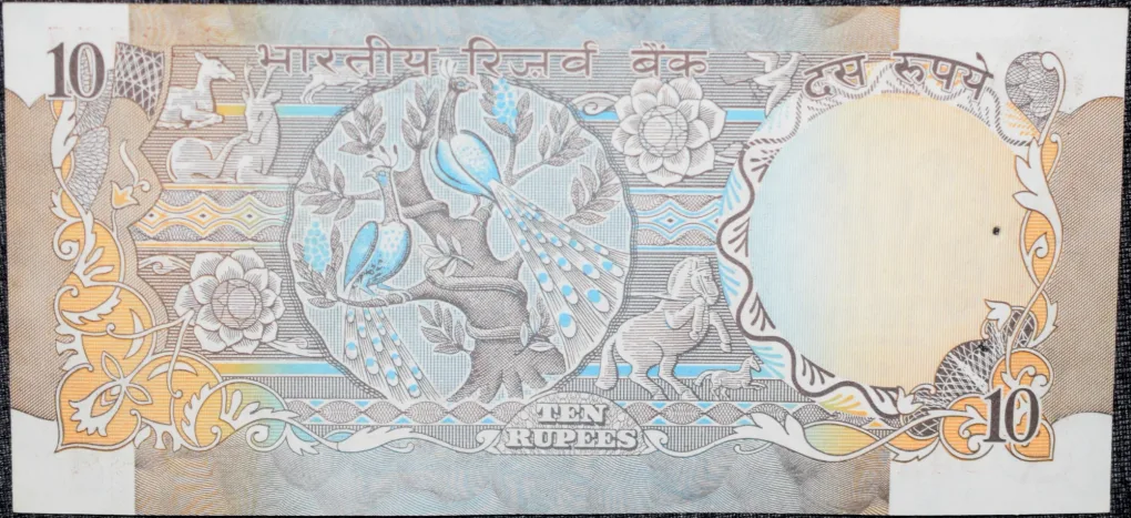 10 Rupees of Republic India (AD 1970-1990) with Two blue peacocks or Indian peafowl (Pavo cristatus) sitting on branches of an old mango tree surrounded by antelopes, horses, flowers, and a bird - R.N. Malhotra